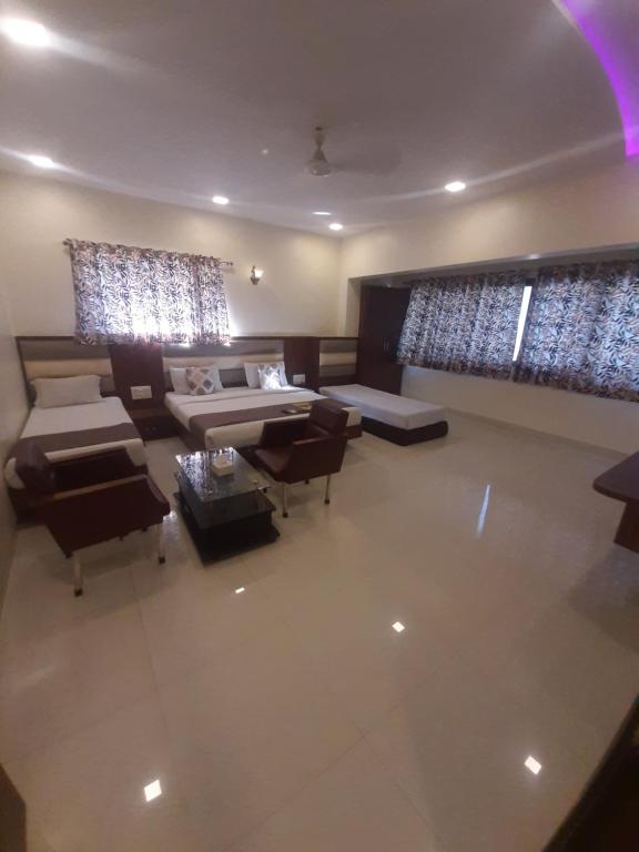Vista aérea de una sala de estar con cama y sillas en Hotel Golden Palms en Bombay