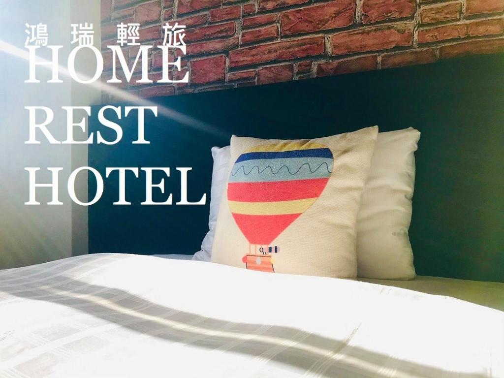 a bedroom with a bed with a brick wall at Home Rest Hotel in Taitung City