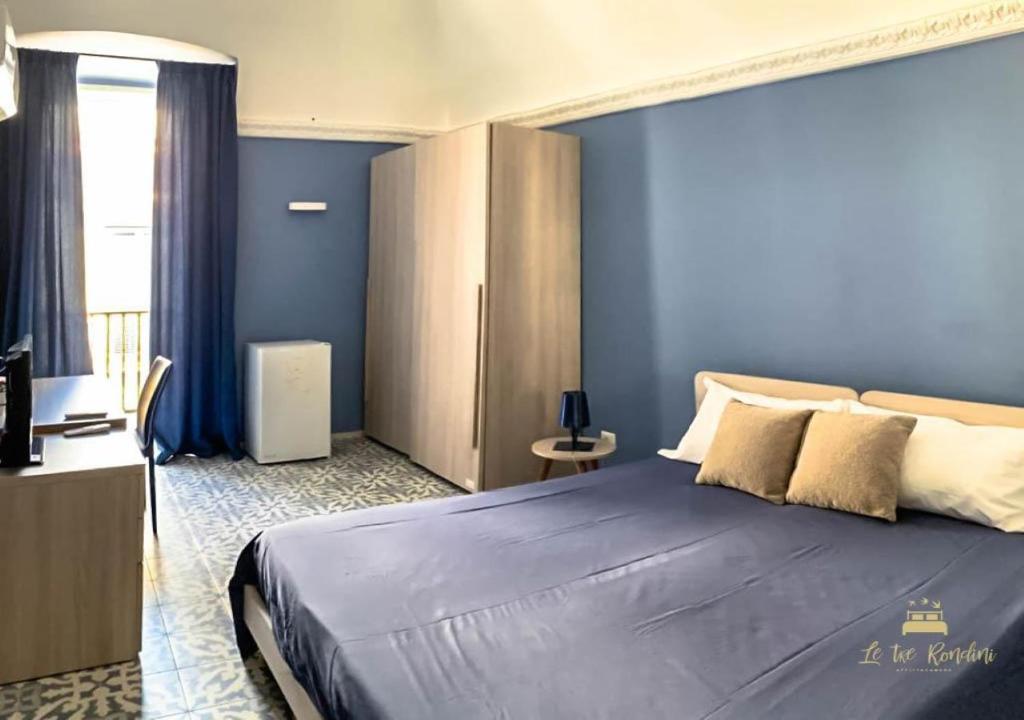 1 dormitorio con 1 cama grande y paredes azules en Le tre rondini, en Barletta