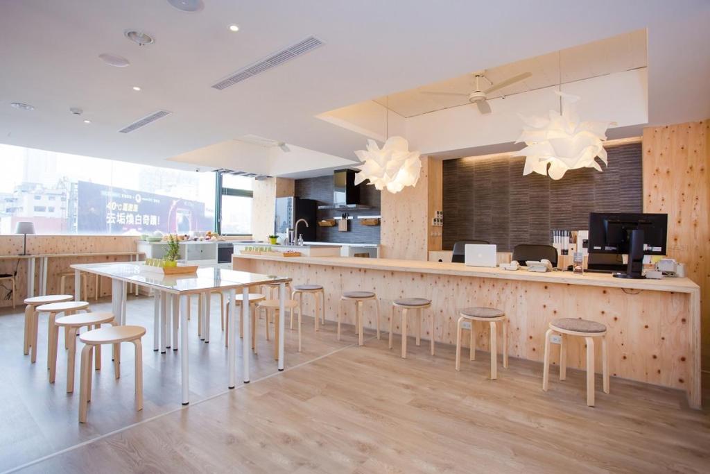 a kitchen with a bar with stools and a table at Mini West Hotel in Taichung