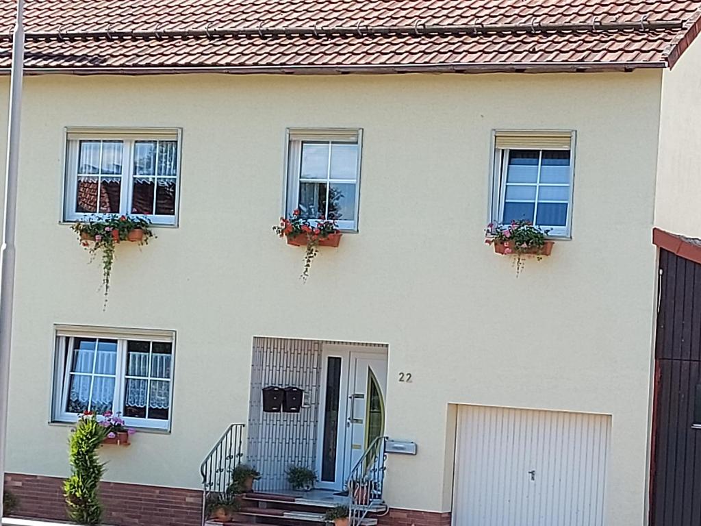 ein weißes Haus mit Fenstern und Topfpflanzen in der Unterkunft Ferienoase Hattorf in Hattorf