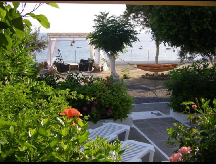 eine Hängematte und Stühle in einem Hof mit Strand in der Unterkunft Villa Tsampika in Pefki Rhodes