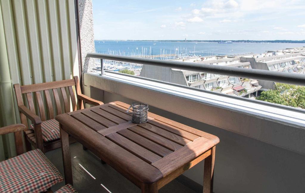 a wooden table on a balcony with a view of the ocean at Ferienwohnung Theodor in Schilksee
