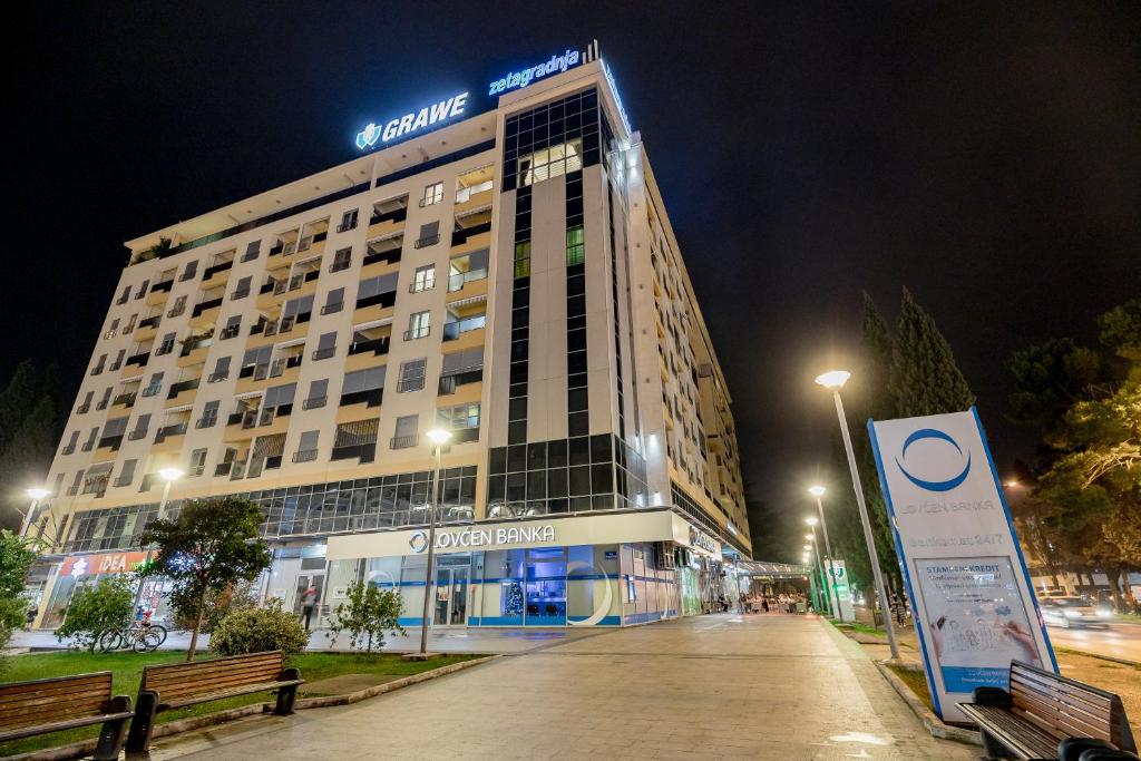 a building with a sign in front of it at night at Apartments Athos in Podgorica