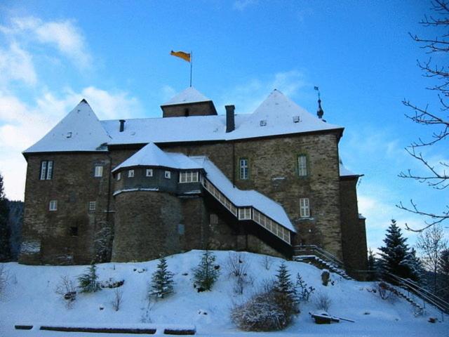 un gran edificio de ladrillo con nieve encima en Hotel und Restaurant Burg Schnellenberg en Attendorn