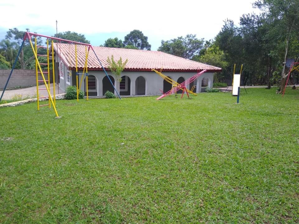 a yard with playground equipment in front of a house at Chácara Temporada Locação em Ibiúna in Ibiúna