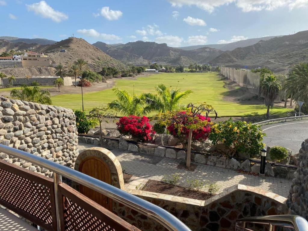 uma vista para um campo de golfe a partir de uma varanda em Villa Tauro Topaz em Mogán