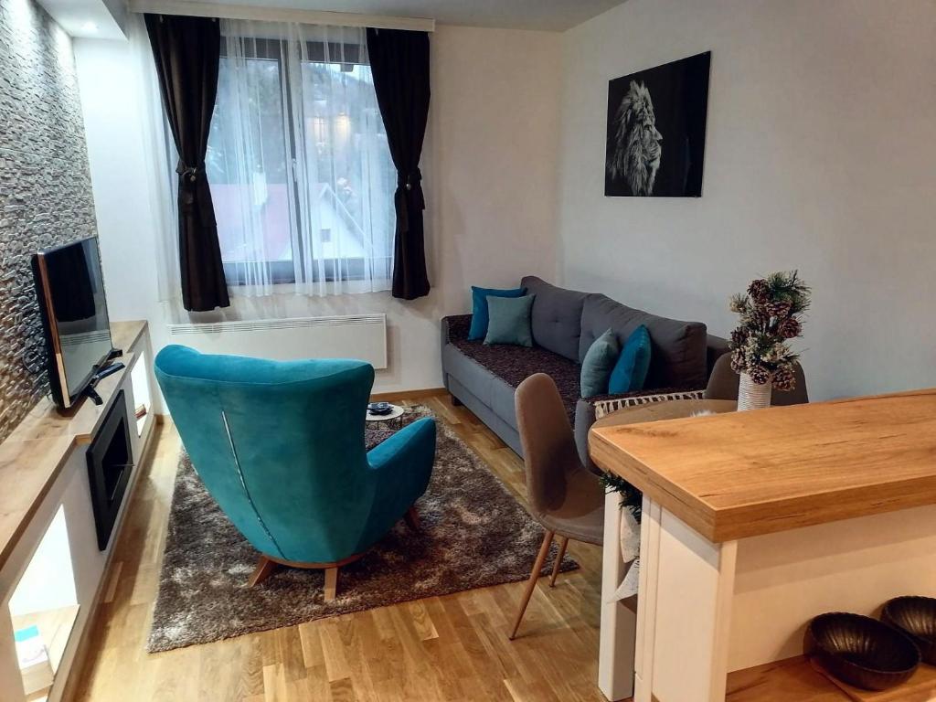 una sala de estar con un sofá y una mesa en Vila Irina Kopaonik - Apartman IN, en Kopaonik