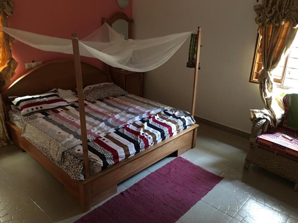 een slaapkamer met een hemelbed en een tapijt bij Irini's apartment in Cotonou