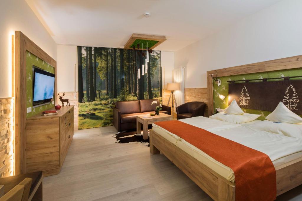 a hotel room with a large bed and a television at Wellnesshotel Tanne in Baiersbronn