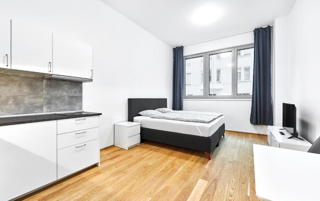 - une chambre avec un lit et une télévision dans l'établissement Apartments Harfa, à Prague