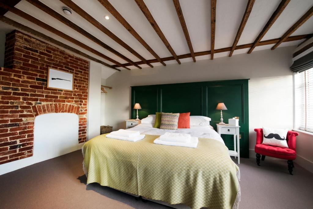 a bedroom with a large bed and a brick wall at The Coach House in Potton