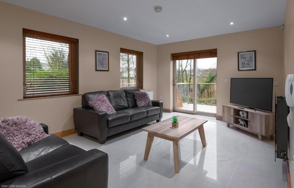 a living room with a couch and a tv at Enniskillen Watersedge Apartments in Enniskillen