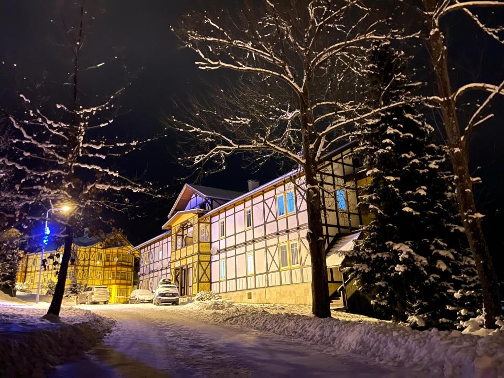 a building covered in snow at night at Vila Mudroň - Studio in Vysoke Tatry - Dolny Smokovec