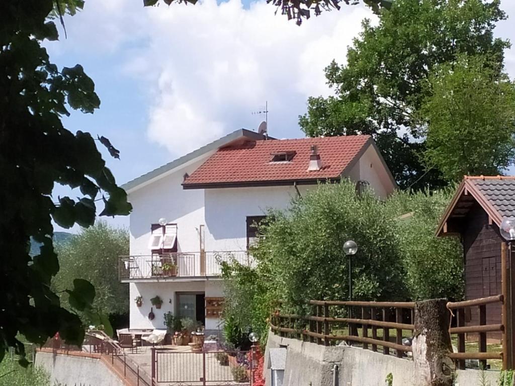 Cette maison blanche dispose d'un balcon et d'une clôture. dans l'établissement AGRITURISMO TERRE VERAE, à Neirone