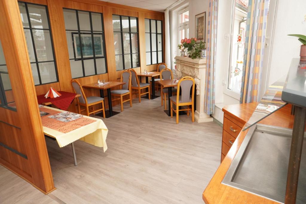 ein Restaurant mit Tischen, Stühlen und Fenstern in der Unterkunft Hotel Birkenwerder in Birkenwerder