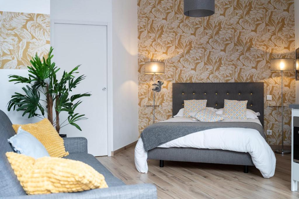 a bedroom with a bed and a couch at Koaloft - Terrasse privée - Lorient centre in Lorient