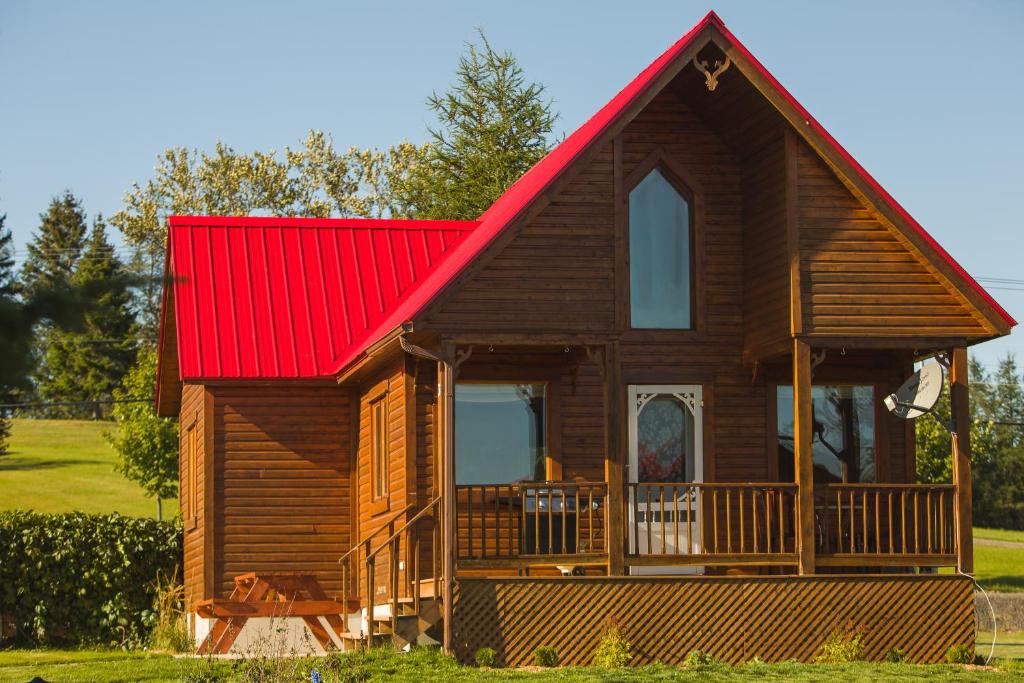 a red and white house with a wooden roof at Chalets de l'Anse Ste Helene in Maria