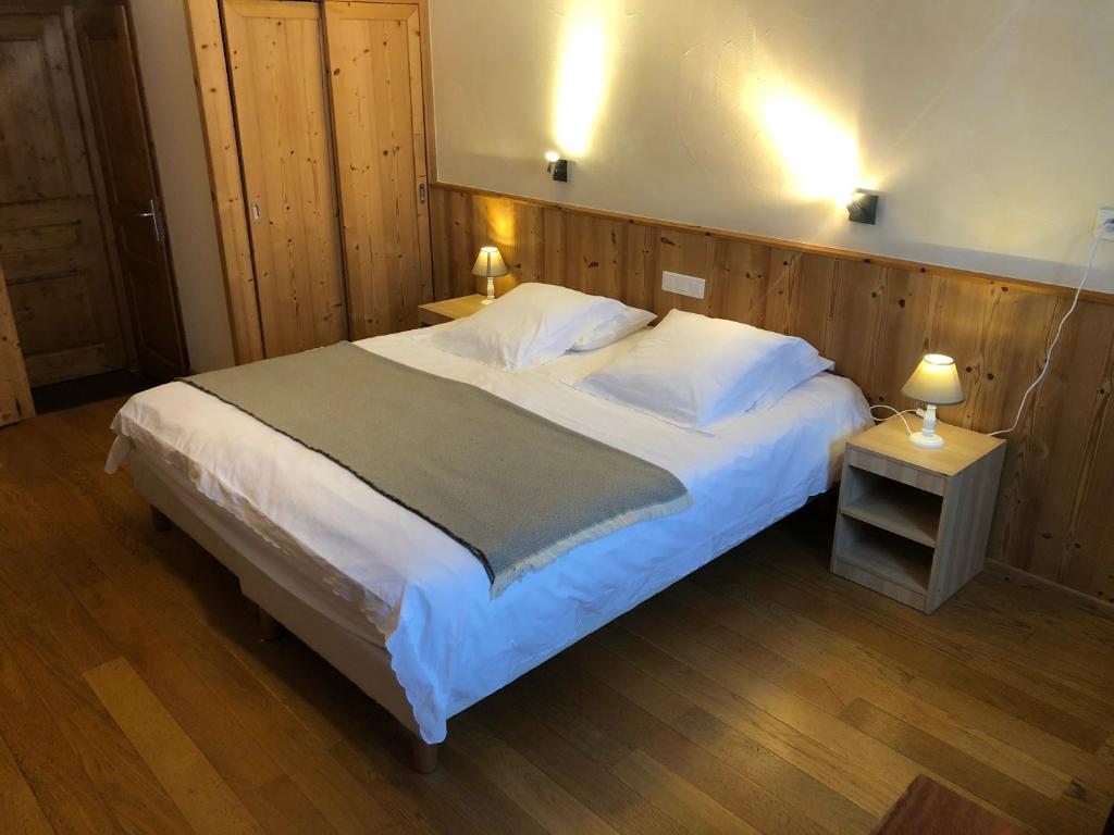 レ・ルースにあるGolf du Rochatの木製の壁のベッドルーム1室(大型ベッド1台付)