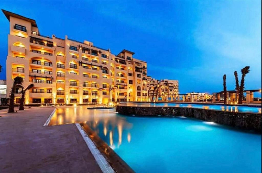 a large building next to a body of water at Hurghada Furnished Appratment - Al Dau Hights Al Mamsha in Hurghada