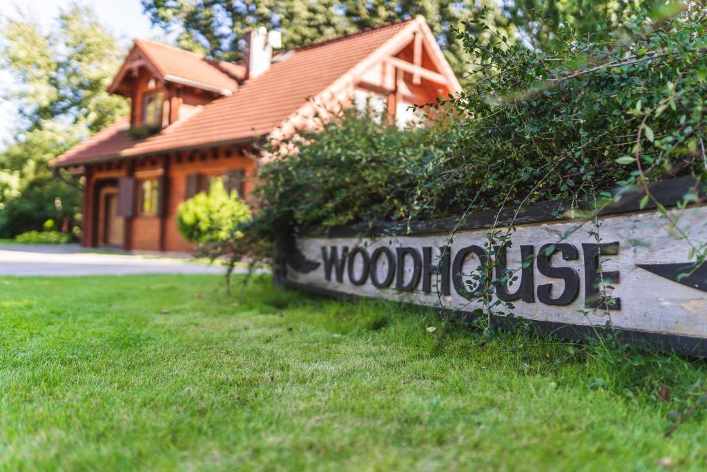 una casa con un cartel en el césped con una casa en Woodhouse, en Łubowo