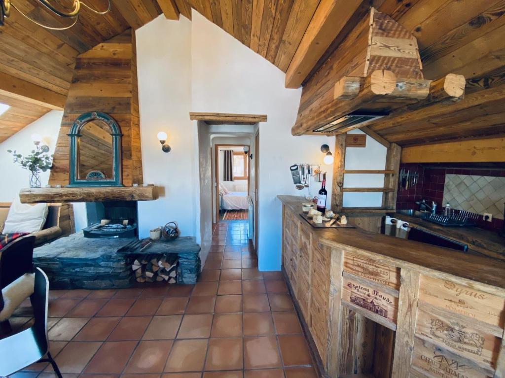 a kitchen with wooden ceilings and a living room at Charming chalet 100m2, Heart of the 3 vallées, Meribel, Les Allues in Les Allues