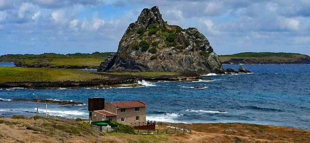 eine Insel im Ozean mit einem Haus am Ufer in der Unterkunft Casa dos Tubarões in Fernando de Noronha