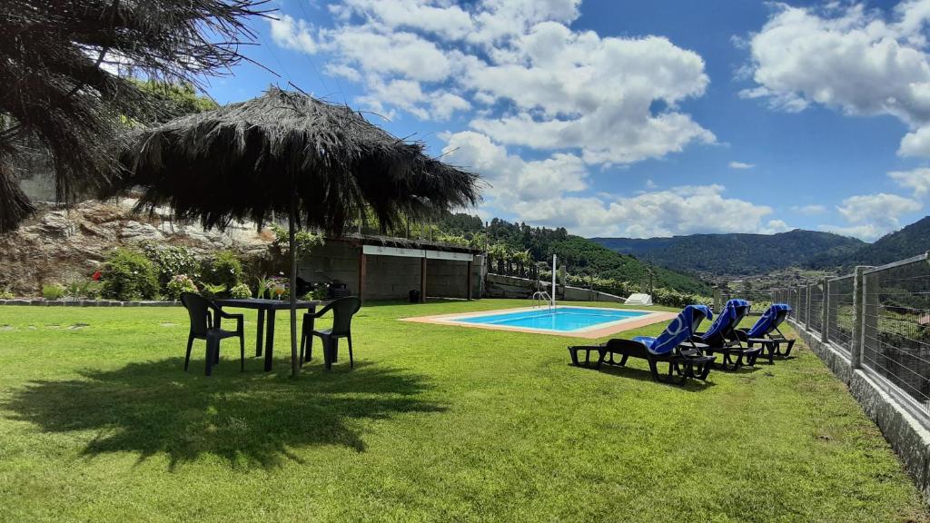 un grupo de sillas y una mesa junto a una piscina en Casa A Chairiña y A Revolta, en Arnoia