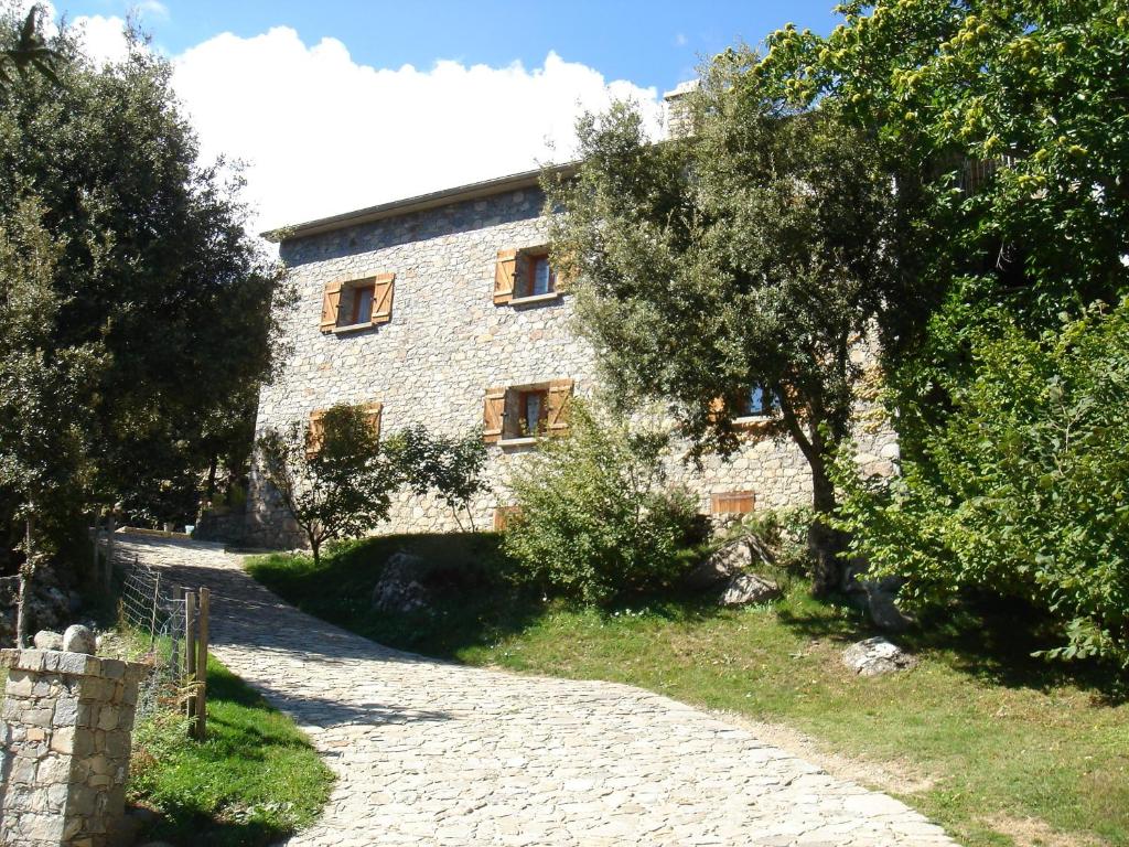 a stone building with trees in front of it at Chambre d'Hôte "Chez Antoinette et Charles" in Venaco