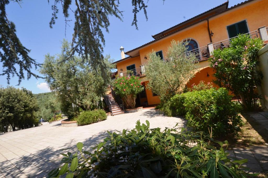 an orange building with trees and bushes in front of it at Poggio Degli Olivi in Monsummano Terme