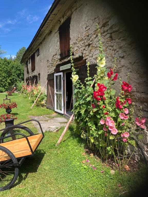 un banco frente a un edificio de piedra con flores en Liste Gård en Ganthem