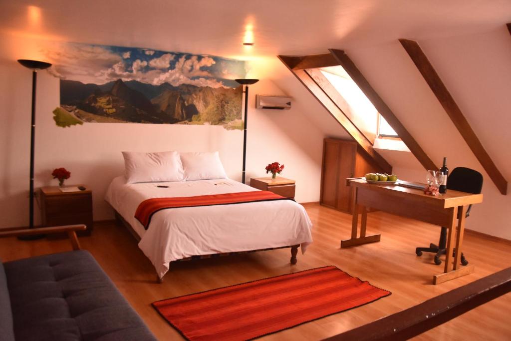 een slaapkamer met een bed, een bureau en een raam bij Los Aticos B&B with Coworking in Cuzco
