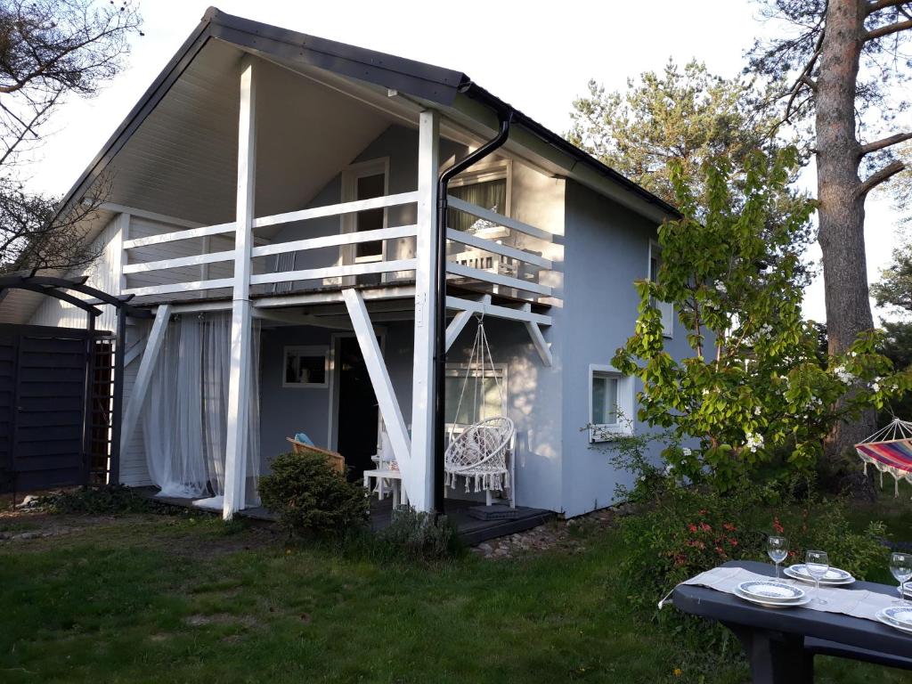 a white house with a porch and a table at Ostrowo domek in Ostrowo