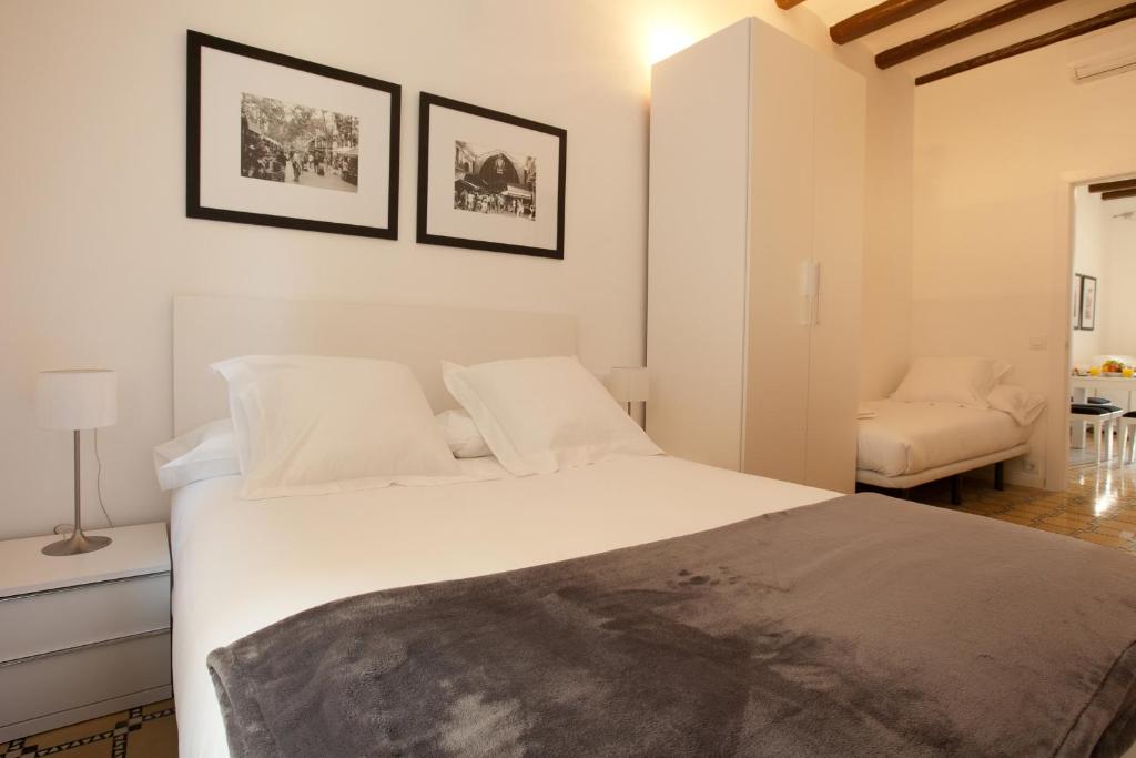 a bedroom with a large white bed and a chair at Barnapartments Basic Gracia in Barcelona