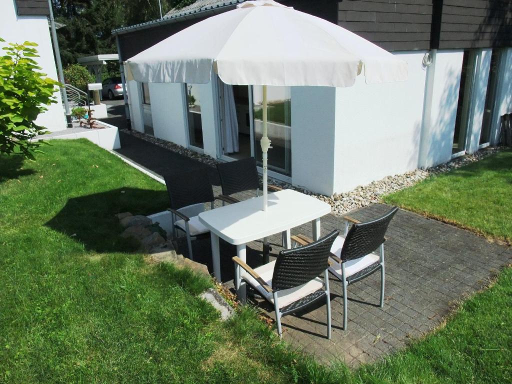 a table and chairs under an umbrella in a yard at Ferienappartment Allendorf in Sundern