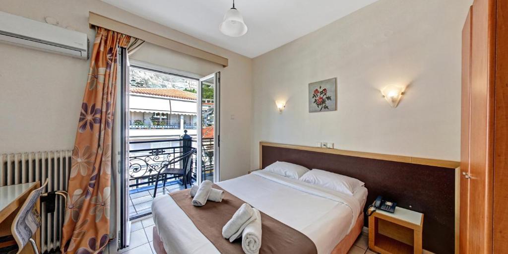 a bedroom with a bed and a balcony at Hotel Rex in Kalabaka