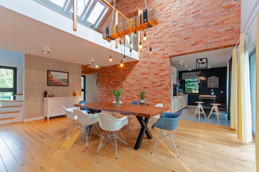 eine offene Küche und ein Esszimmer mit einer Ziegelwand in der Unterkunft Wiselka Holiday House-1,2km to the beach; 5 bedrooms, 3 bahrooms; fire place. Private sauna! in Wisełka