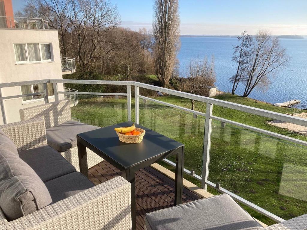 a balcony with a table with a bowl of fruit on it at Ferienwohnung Ascheberg am See in Ascheberg