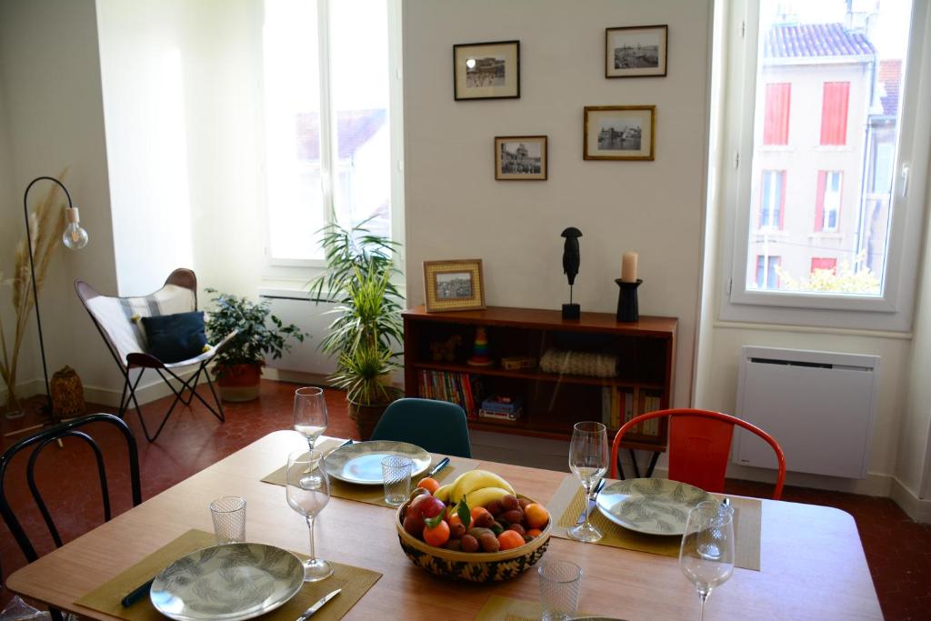 une table de salle à manger avec un bol de fruits dessus dans l'établissement 85 m2 centre ville 2 mn vieux Port au calme, à Marseille
