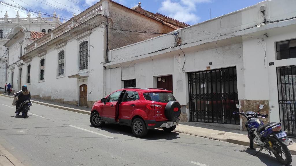 czerwony samochód zaparkowany po stronie ulicy w obiekcie Tanguitos w mieście Sucre