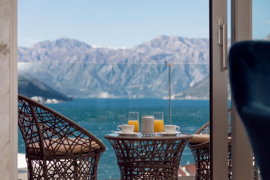 una mesa con bebidas y vistas al océano en Bonintro Lux Apartment, en Kotor