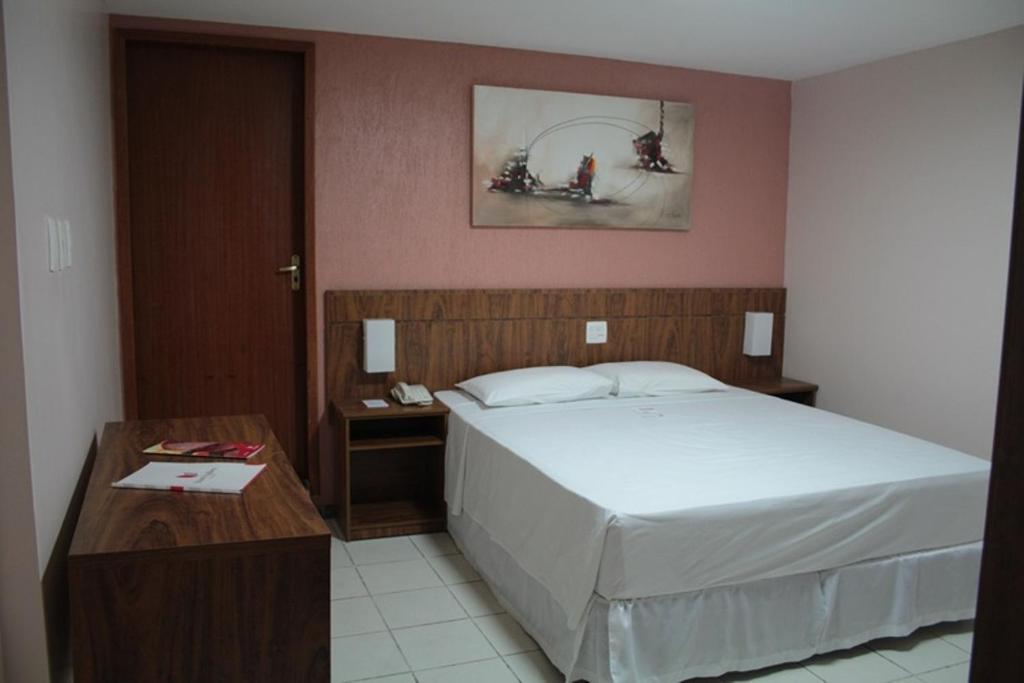 伊帕廷加斯蒂尔山谷经济型酒店的一间卧室，里面有一张大床和一张桌子。