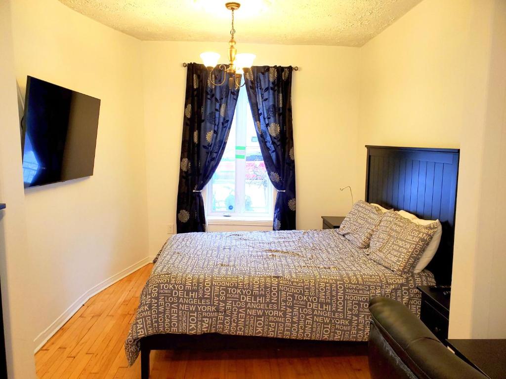 Schlafzimmer mit einem Bett und einem Fenster in der Unterkunft Maison Montplaisir in Montreal