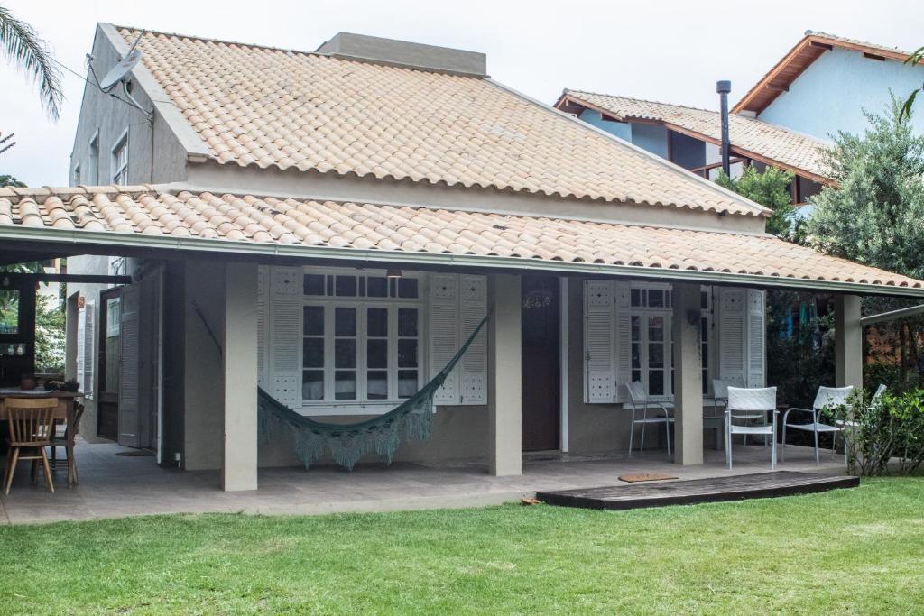 Una casa con un porche con una hamaca. en Casa de Praia Florianópolis, en Florianópolis