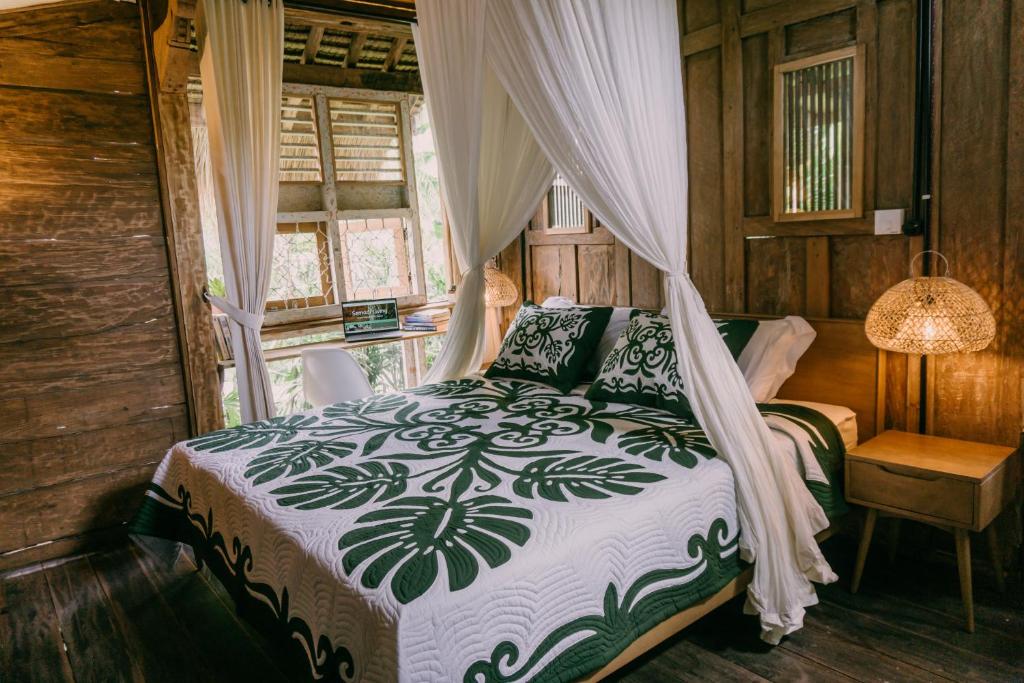 1 dormitorio con 1 cama con dosel en Wooden house at Semadi living en Sukawati
