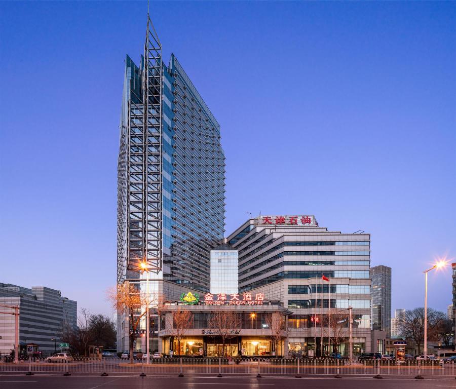 ein hohes Gebäude mit einem Kran darüber in der Unterkunft Golden Ocean Hotel Tianjin in Tianjin