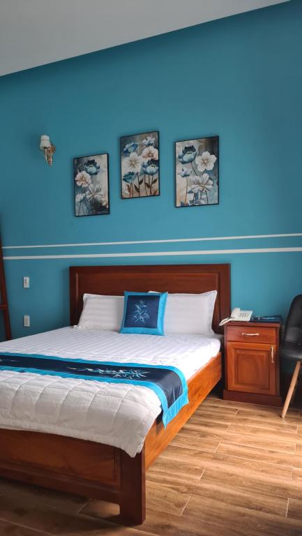Schlafzimmer mit einem Bett mit blauer Wand in der Unterkunft LẠI NGUYỄN BOUTIQUE HOTEL in Cần Thơ