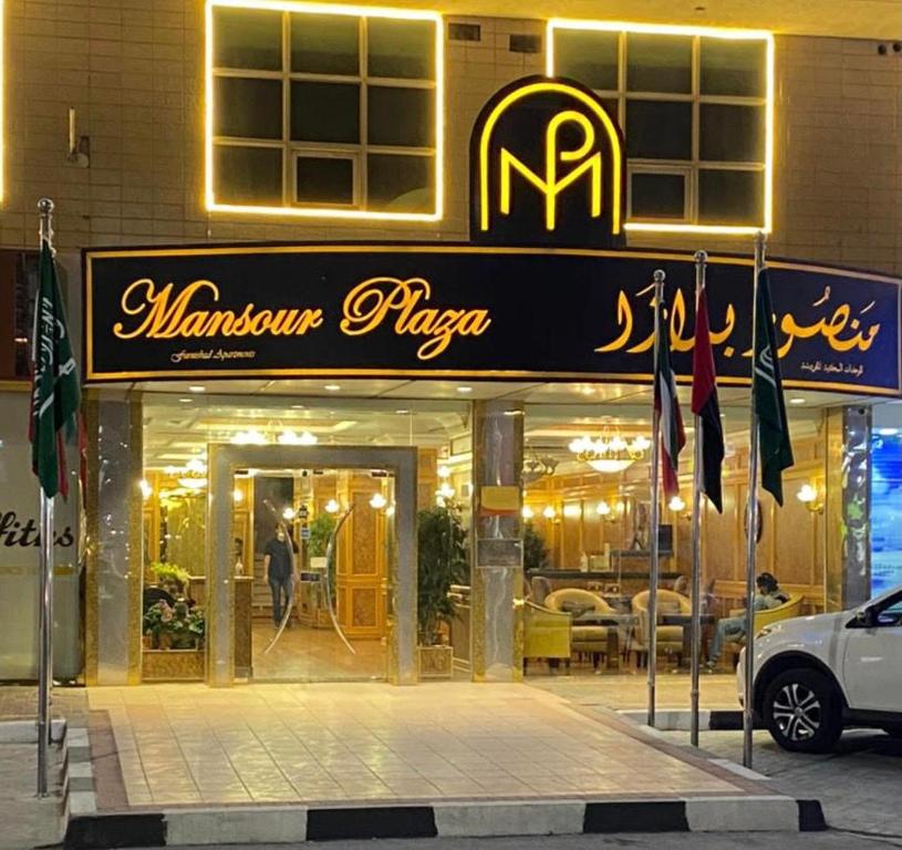 ein Restaurant mit einem Schild auf der Vorderseite eines Gebäudes in der Unterkunft Mansour Plaza Hotel Apartments in Dammam
