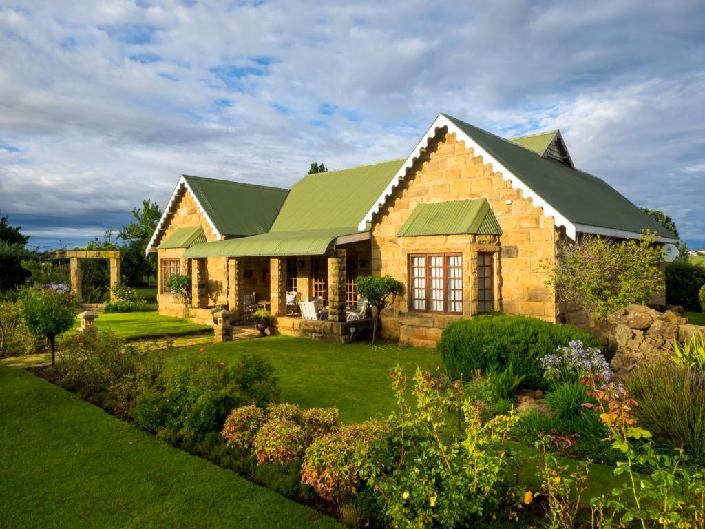 uma grande casa de pedra com um telhado verde em Fouriesburg Country Inn em Fouriesburg