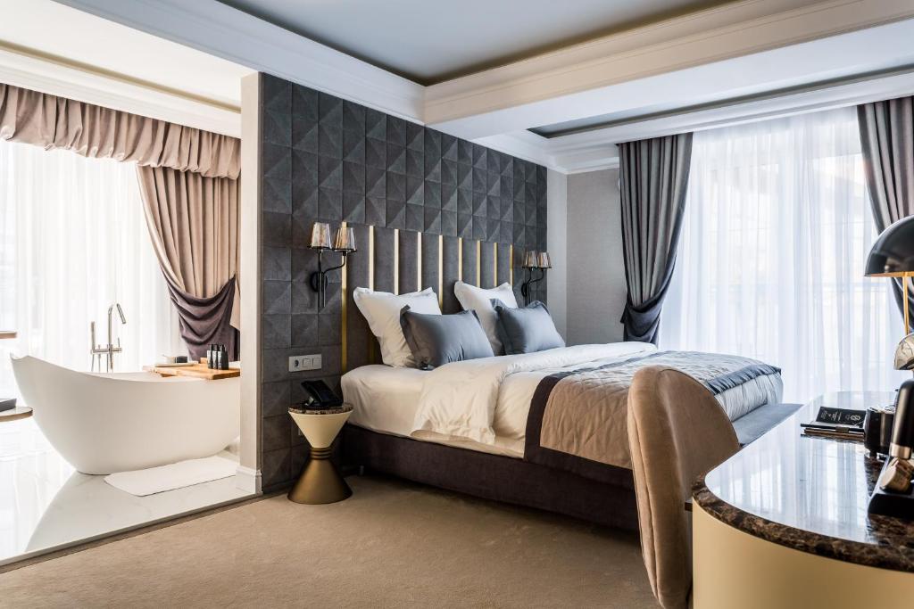 a bedroom with a bed and a bath tub and a bath tub at HISTORY Boutique Hotel & SPA in Irkutsk